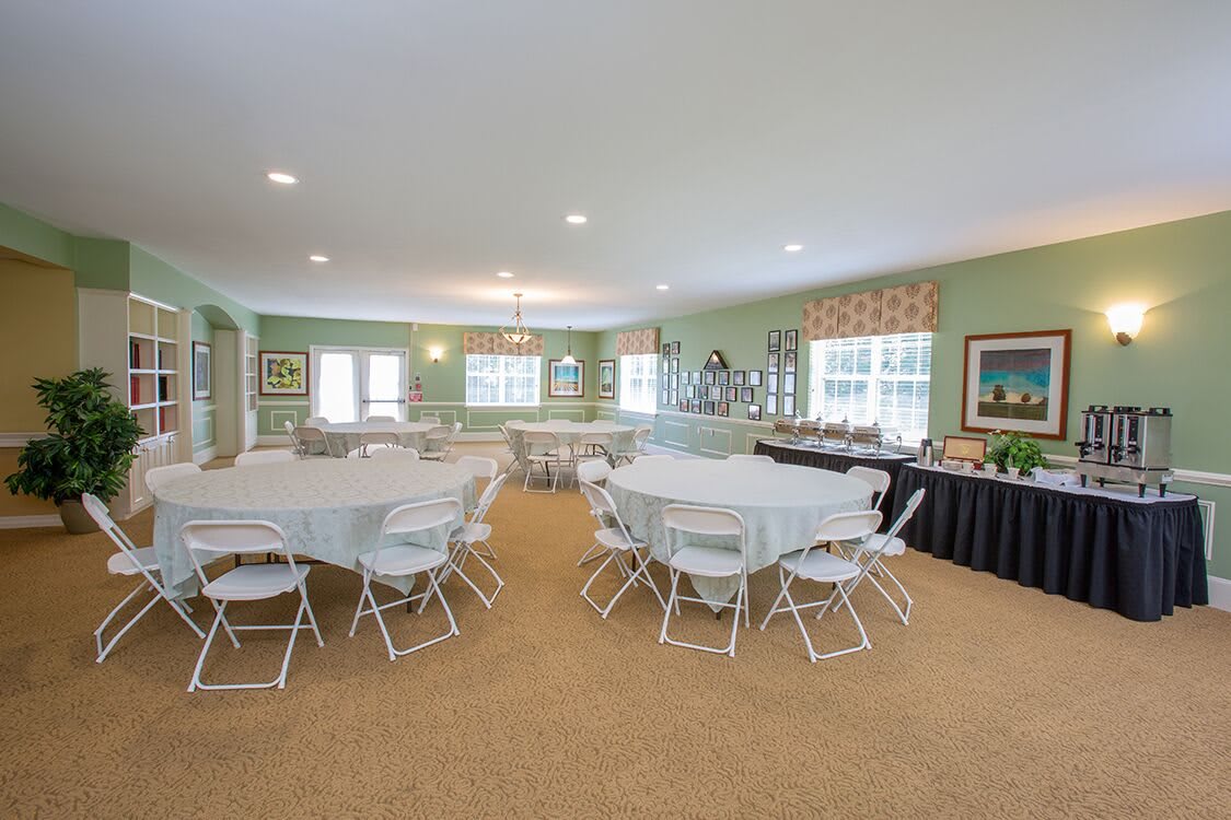A spacious, well-lit indoor event space set up with round tables and chairs.