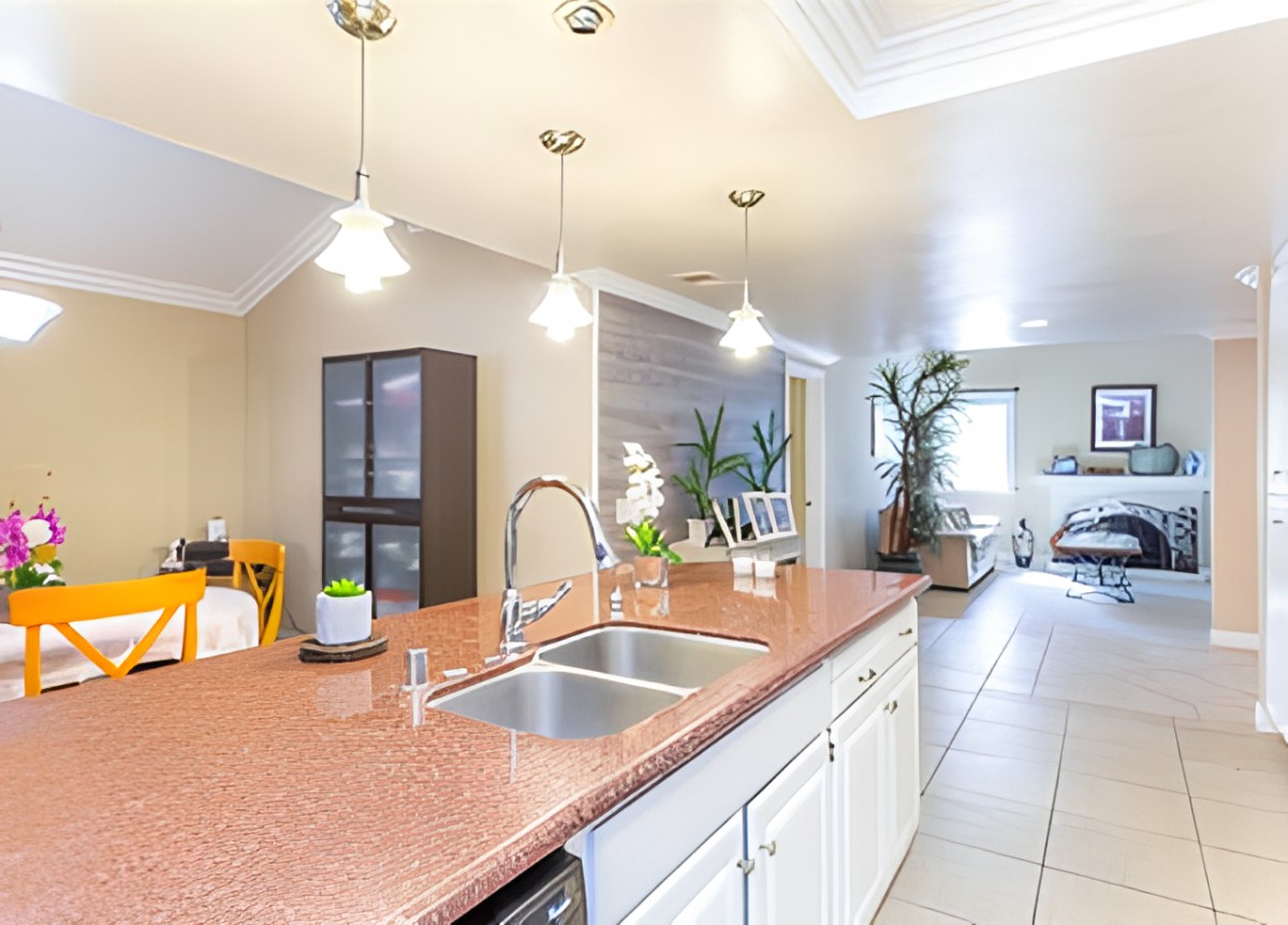 Modern kitchen with an island counter and pendant lights, featuring bright and open space.