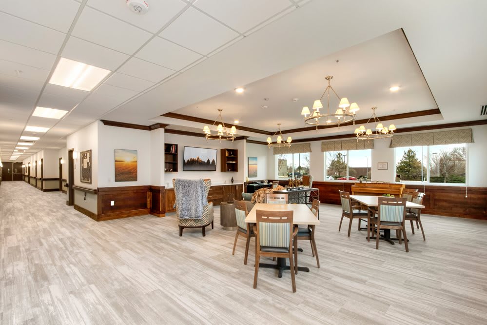 A bright, modern dining area with elegant chandeliers and wooden flooring.