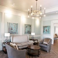 A beautifully designed living room with elegant seating, modern artwork, and stylish lighting.