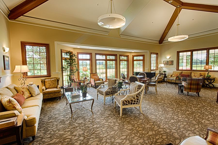 A spacious and elegantly furnished living room with large windows and various seating arrangements.