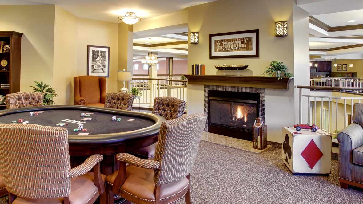 A cozy living room featuring a poker table and fireplace.