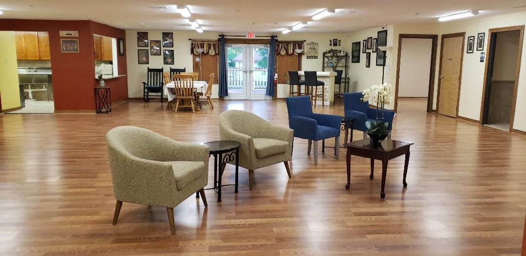 A well-arranged sitting area with comfortable chairs and tables on a wooden floor.