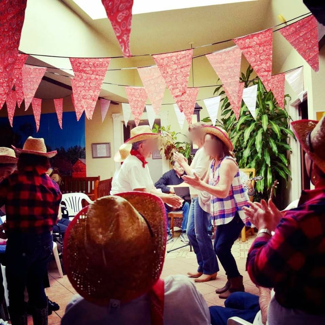 People enjoying a lively indoor party with cowboy hats and decorative bunting.