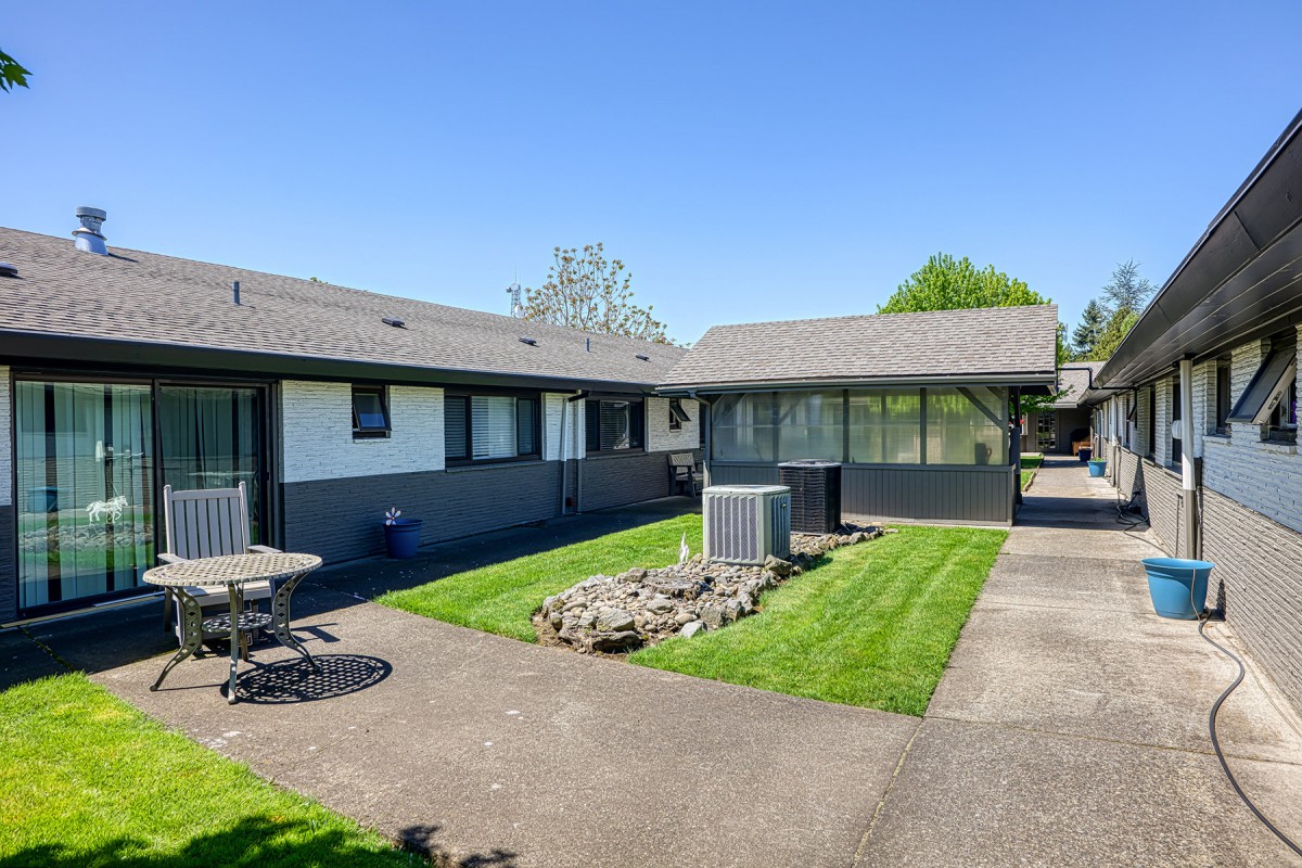 A residential house with a well-maintained lawn and patio area.