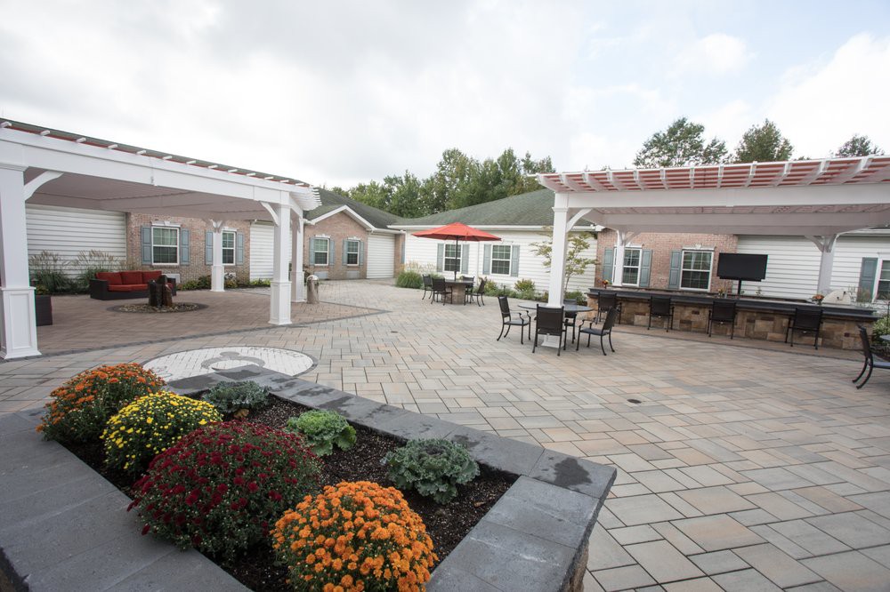 A peaceful courtyard with seating areas and pergolas surrounded by well-maintained landscaping.