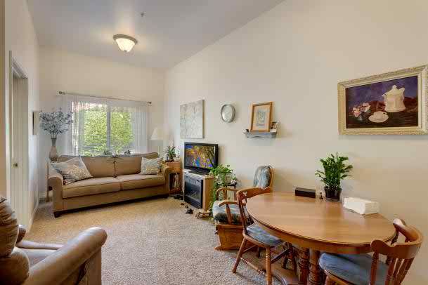 A cozy living room with a sofa, TV, and dining table.