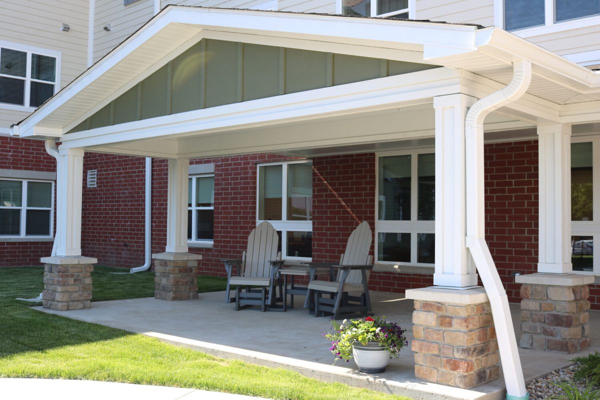 A front porch with chairs and a small table.