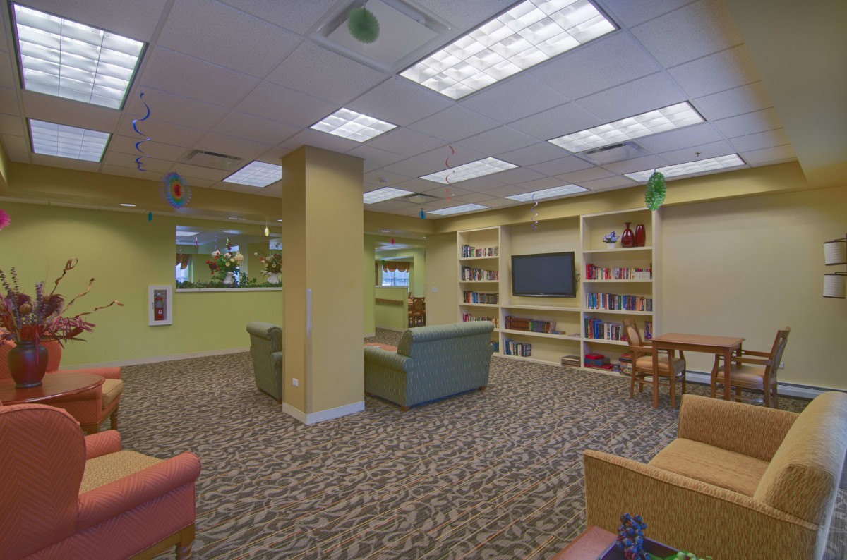 A cozy library reading room with comfortable seating and bookshelves.