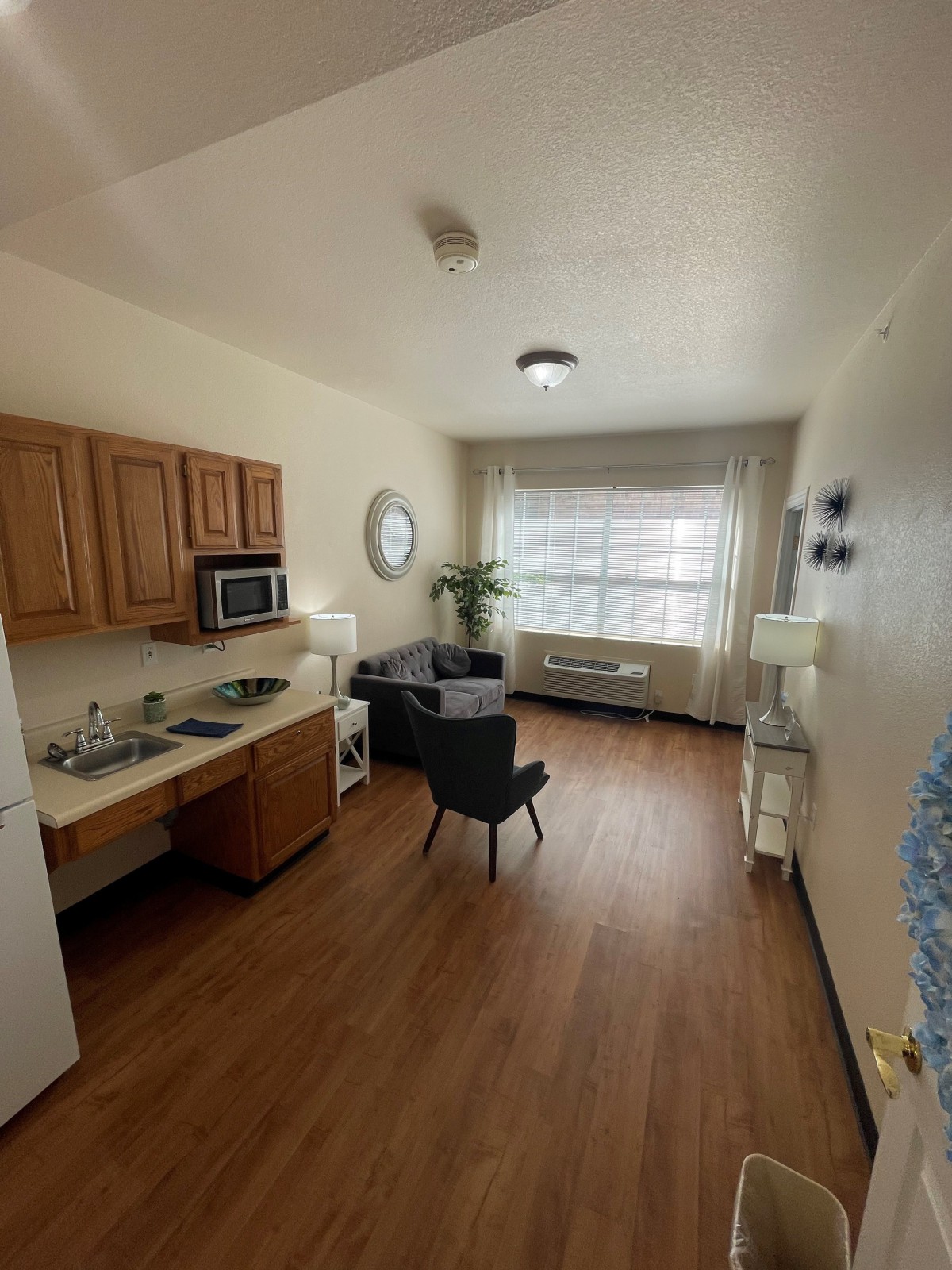 A cozy apartment featuring a kitchenette and a well-lit living area.