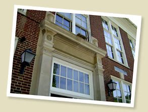 A view of a brick building facade featuring large windows and decorative stonework.