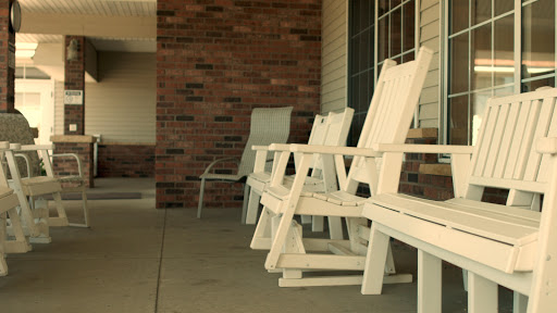 A serene outdoor setting featuring white wooden chairs on a porch.