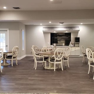 A modern dining area with several tables and chairs set on a hardwood floor.