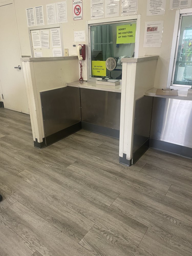 A reception area with a front desk and laminate wood flooring.