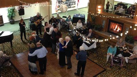 Couples dancing at a festive indoor event with live music.