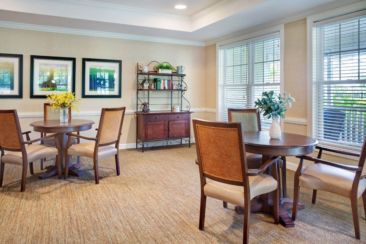 A cozy dining area with wooden tables, upholstered chairs, and decorative elements.