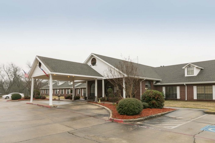 A single-story building with a covered entrance and landscaped surroundings.