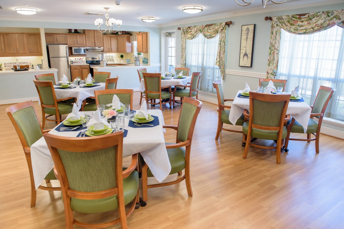 A well-arranged dining area with elegant table settings and a view of the adjacent kitchen.