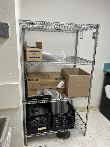 A metal wire shelving unit displaying various boxes and storage containers.