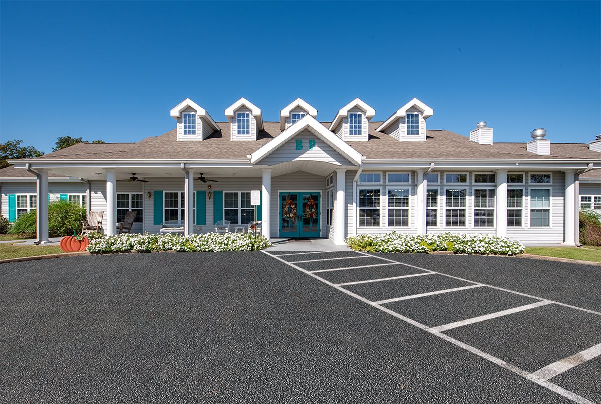A charming house with multiple dormer windows and a wide driveway.