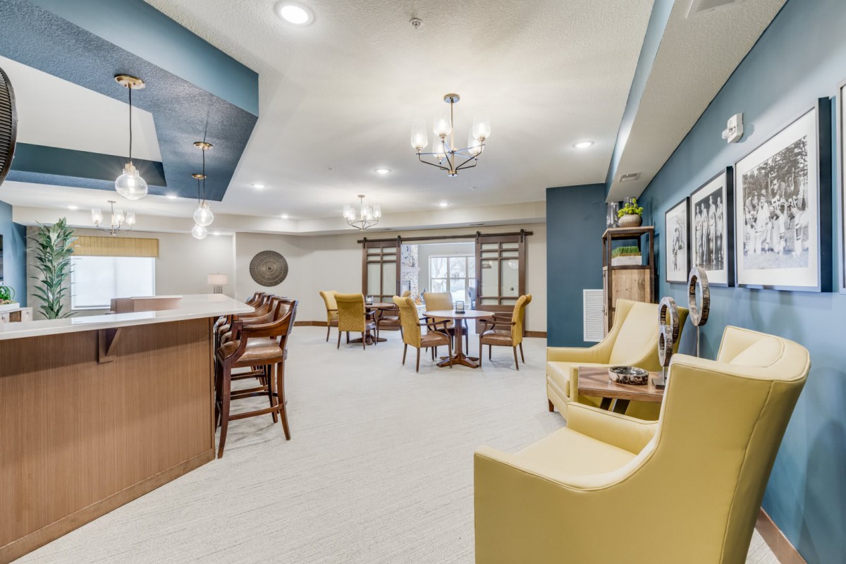 A spacious modern living room with comfortable seating and a bar area.