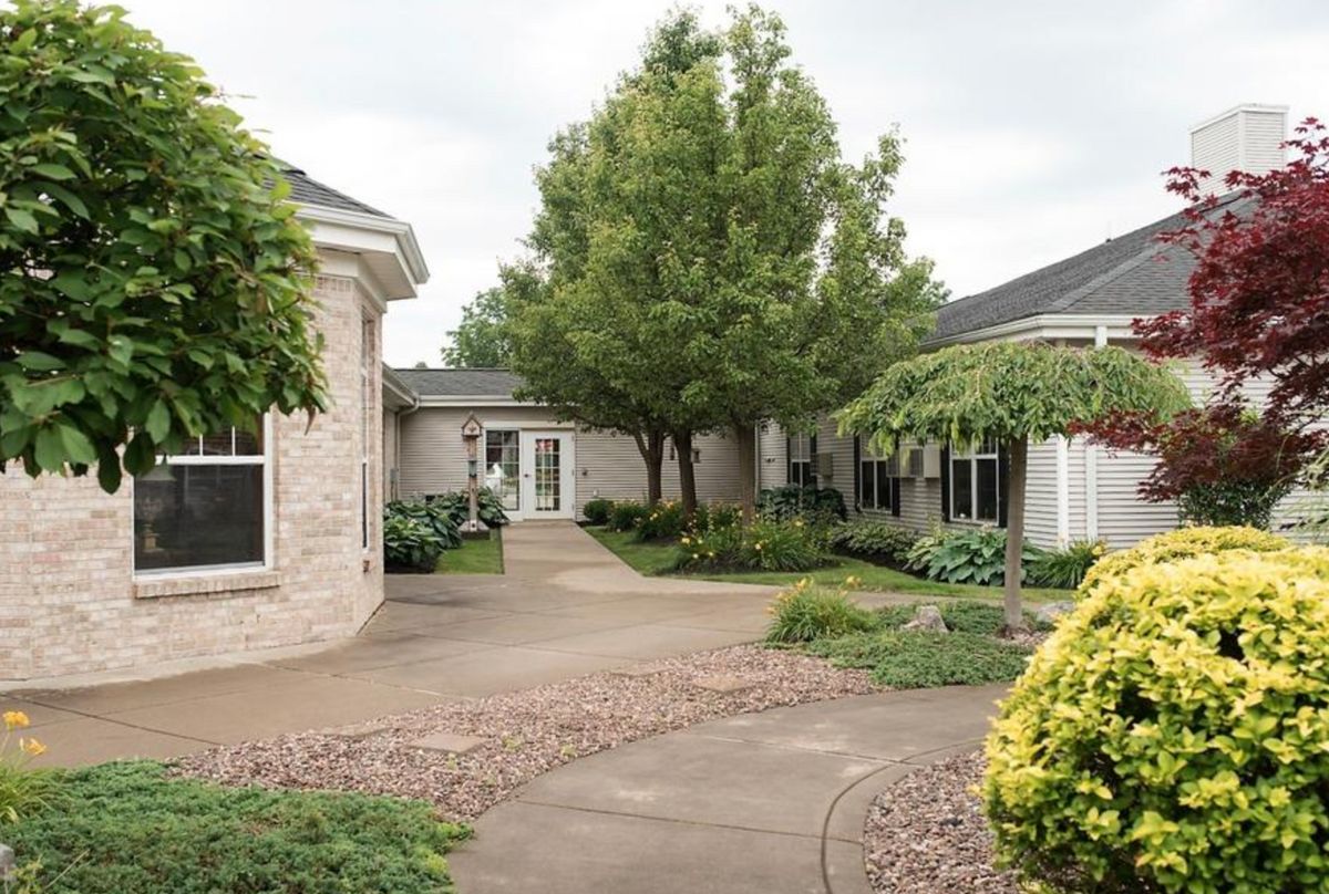 A serene courtyard with lush greenery and a winding pathway.
