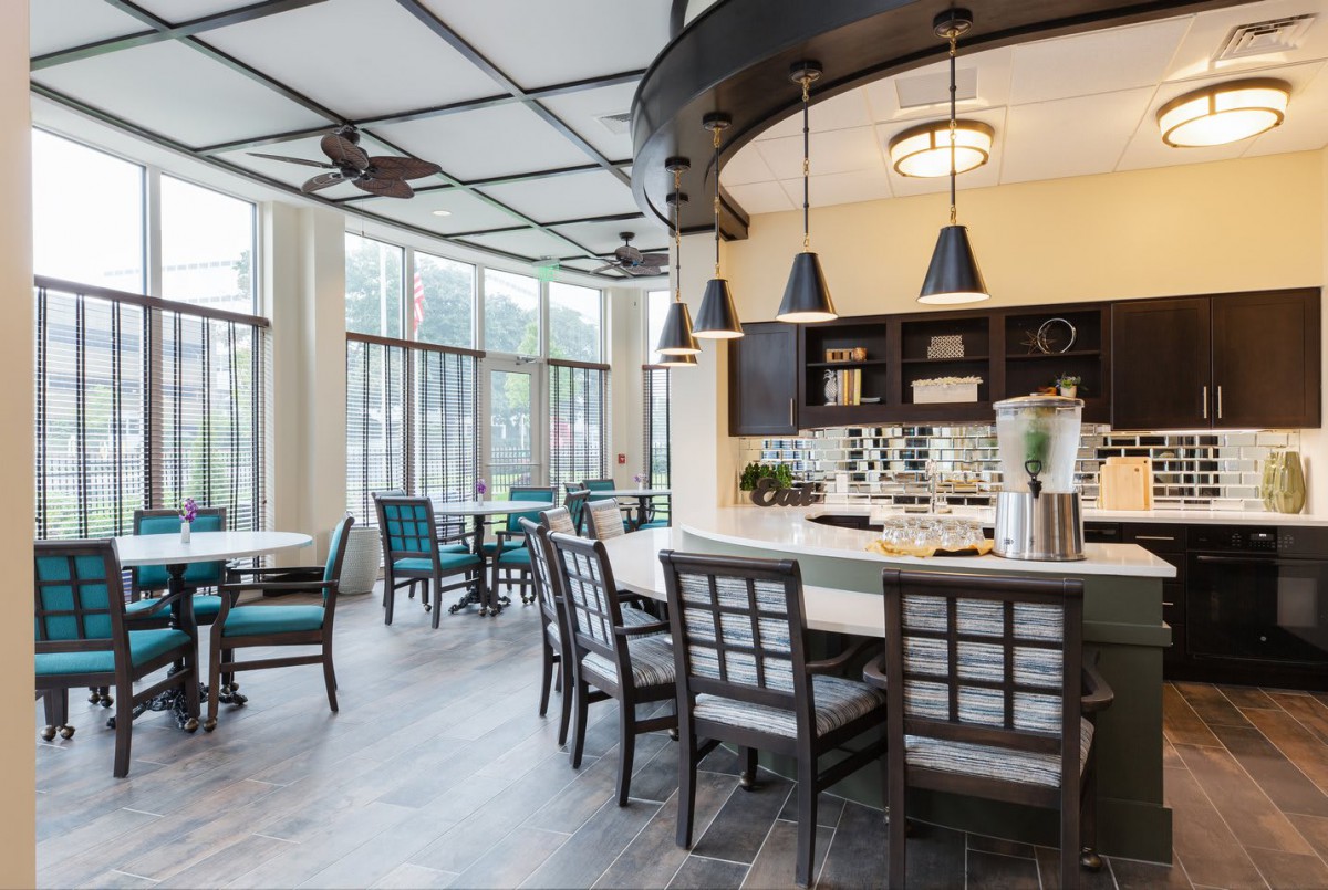 Modern kitchen and dining area with ample natural light and stylish furniture.