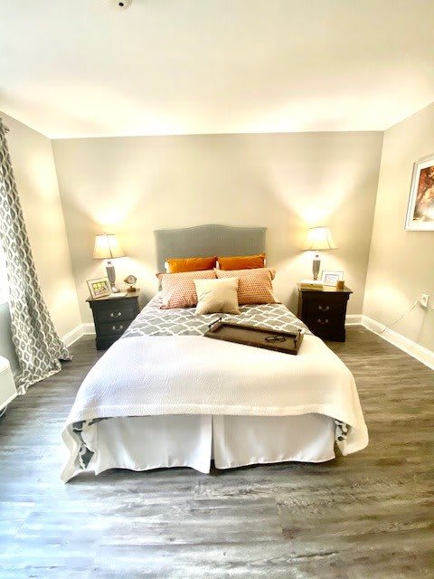 A cozy and modern bedroom with a neatly made bed, decorative pillows, and bedside lamps.
