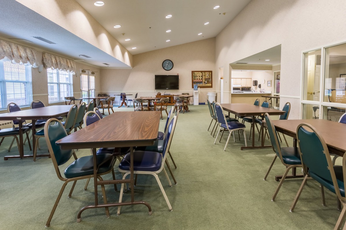 A spacious community center room with tables and chairs arranged for meetings.