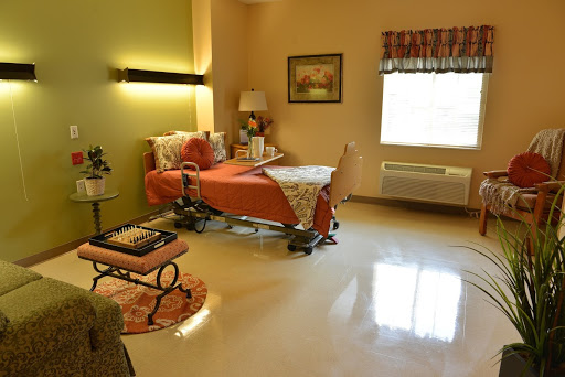 A well-lit hospital room designed for patient comfort, featuring a neatly made bed and cozy seating.