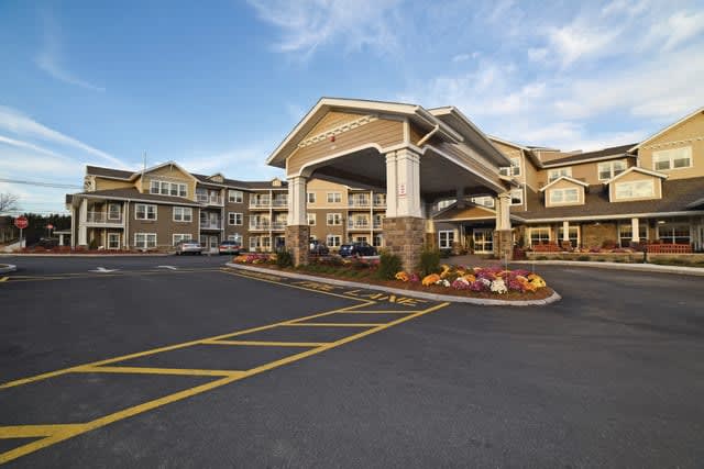 A view of a hotel exterior with a spacious entrance and landscaped surroundings.