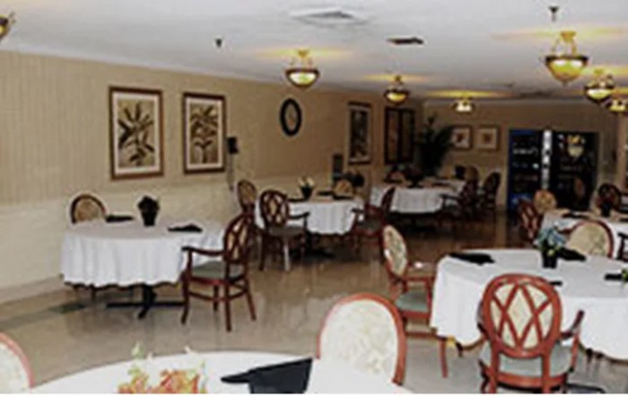 A cozy restaurant interior with several tables and chairs arranged in a warmly decorated dining area.