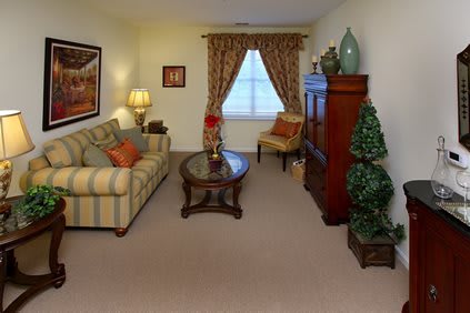 A cozy living room with a striped sofa, wooden coffee table, and elegant curtains.