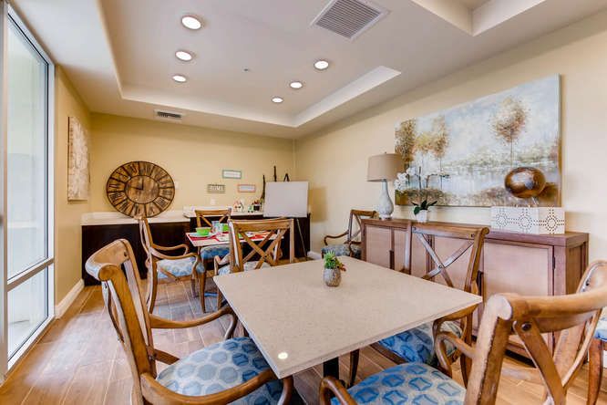 A cozy dining room with a central table and chairs, adorned with decorative elements and artwork.
