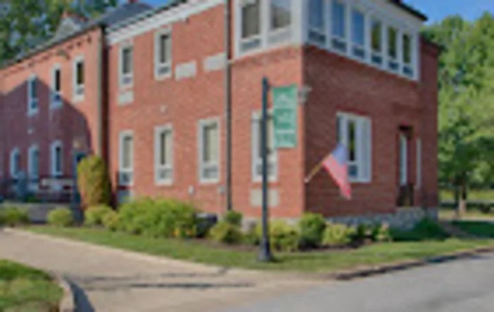 A brick building with a flag on a street corner.
