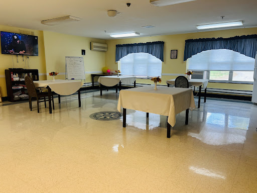 A spacious and well-lit indoor room set up with several tables and chairs.