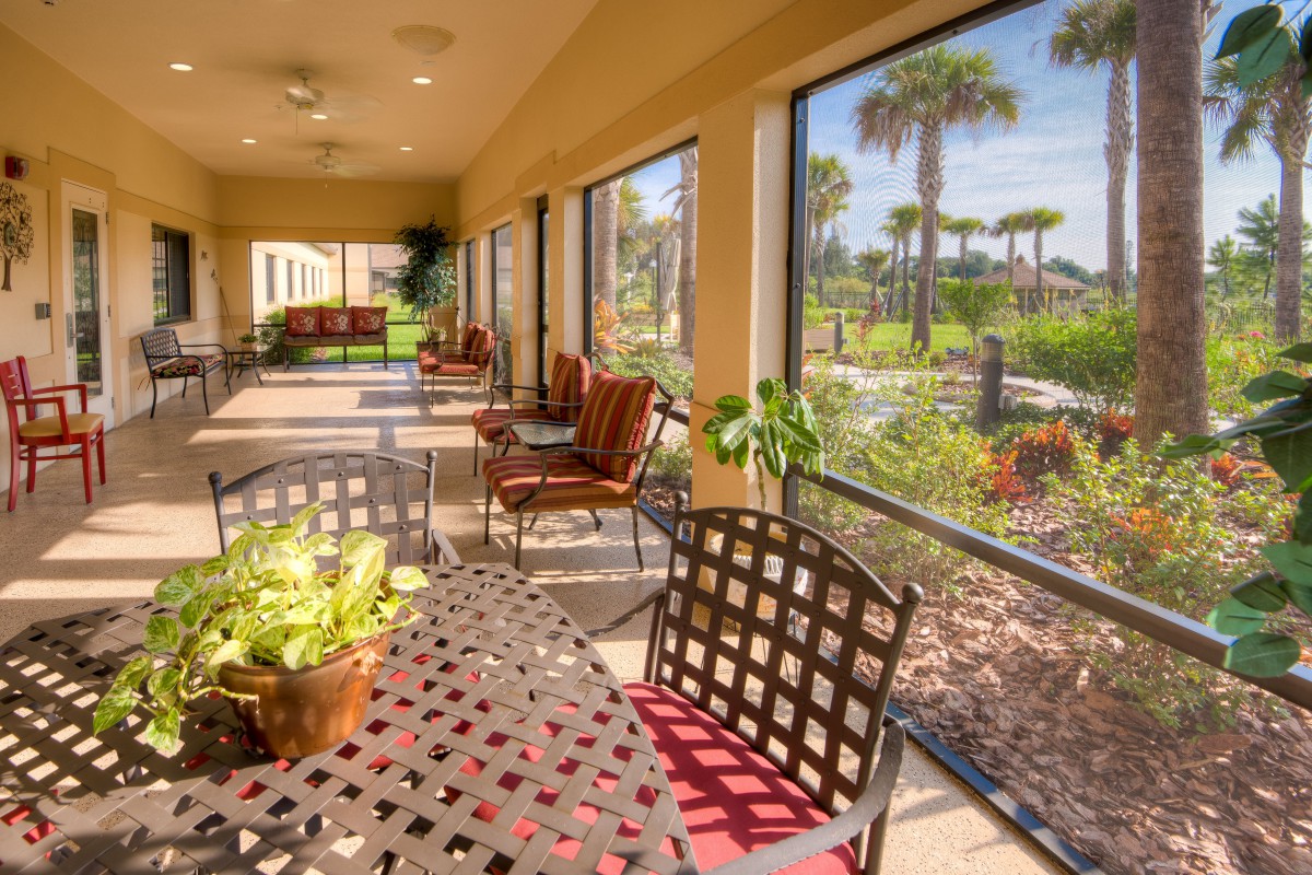 A sunny patio with outdoor seating and a garden view.