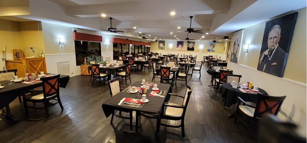 A spacious and neatly arranged restaurant interior with empty tables and chairs.