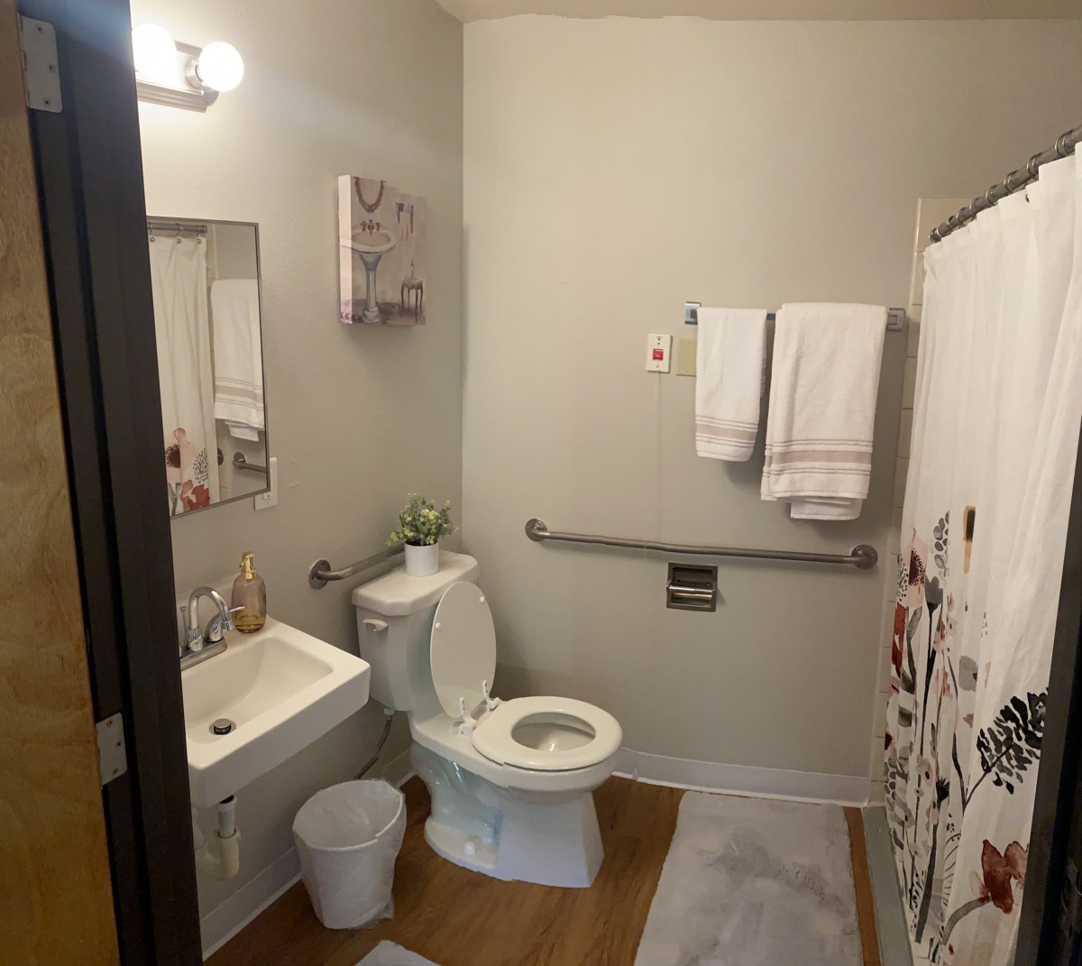 A clean and well-organized bathroom with a toilet, sink, and decorative shower curtain.