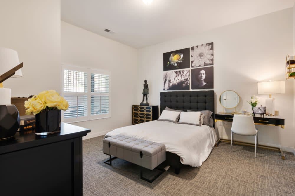 A modern bedroom featuring a stylish bed with decorative artwork on the wall and neutral color palette.