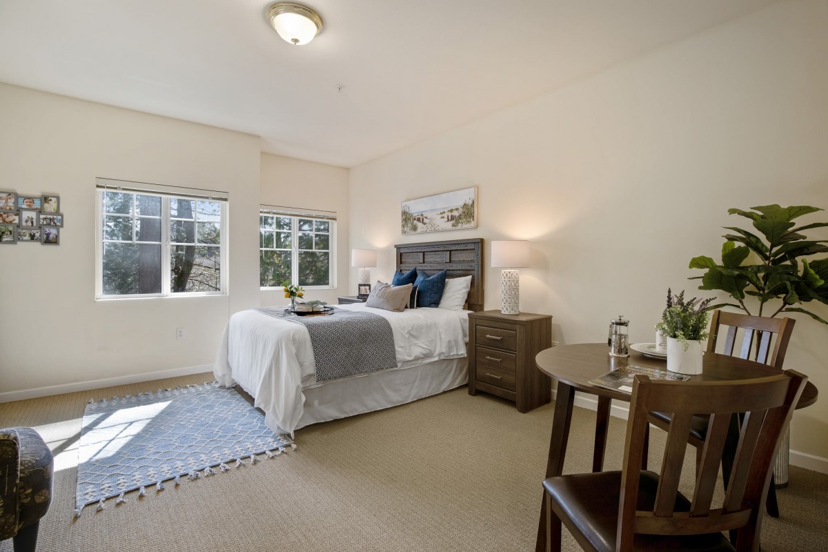A cozy and well-lit bedroom featuring modern furniture and soothing decor.