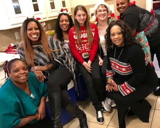 A group of people enjoying a holiday gathering, dressed in festive attire and smiling.