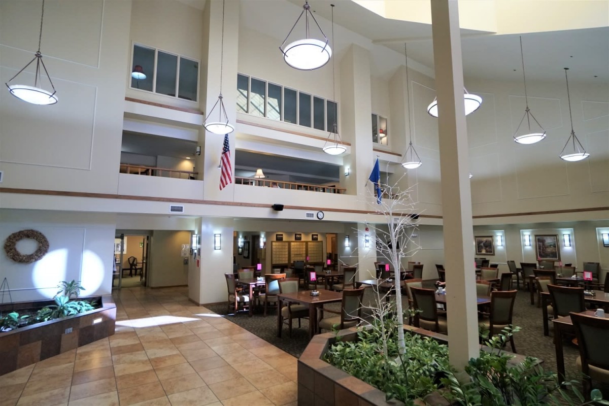 A spacious atrium with dining tables, flags, and ample natural light.