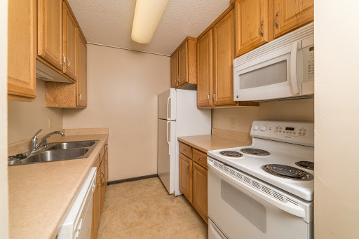 A compact kitchen featuring wooden cabinets and essential appliances.