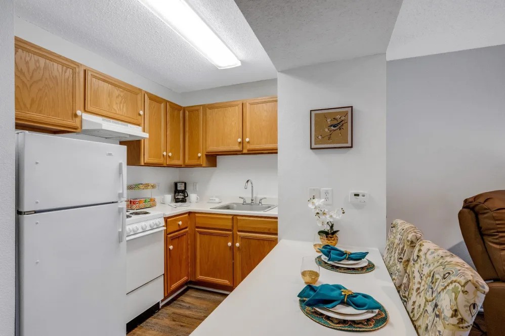 A cozy kitchen with wooden cabinets and a small dining area.