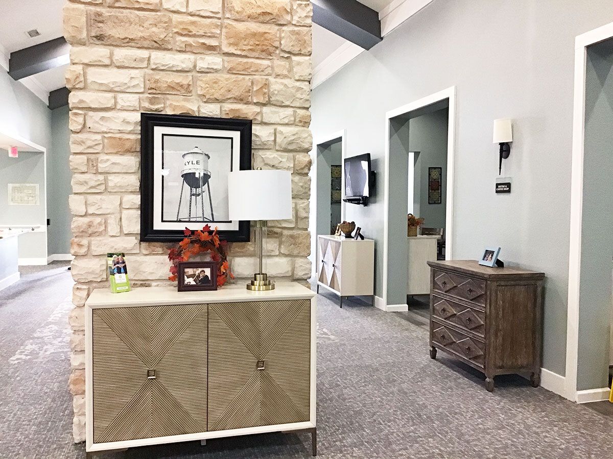 A well-decorated office interior with a stone feature wall, stylish furniture, and framed artwork.