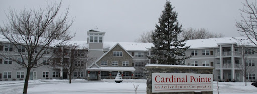 A picturesque assisted living facility covered in snow, showcasing its charming architecture during winter.
