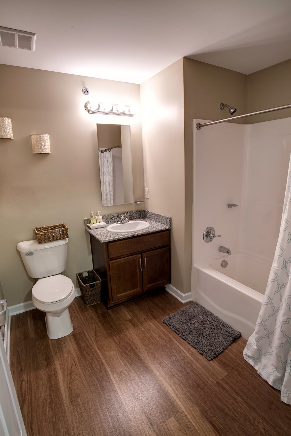 A modern bathroom with a toilet, sink, and bathtub.