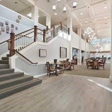 A spacious and modern lobby featuring a staircase and elegant lighting.