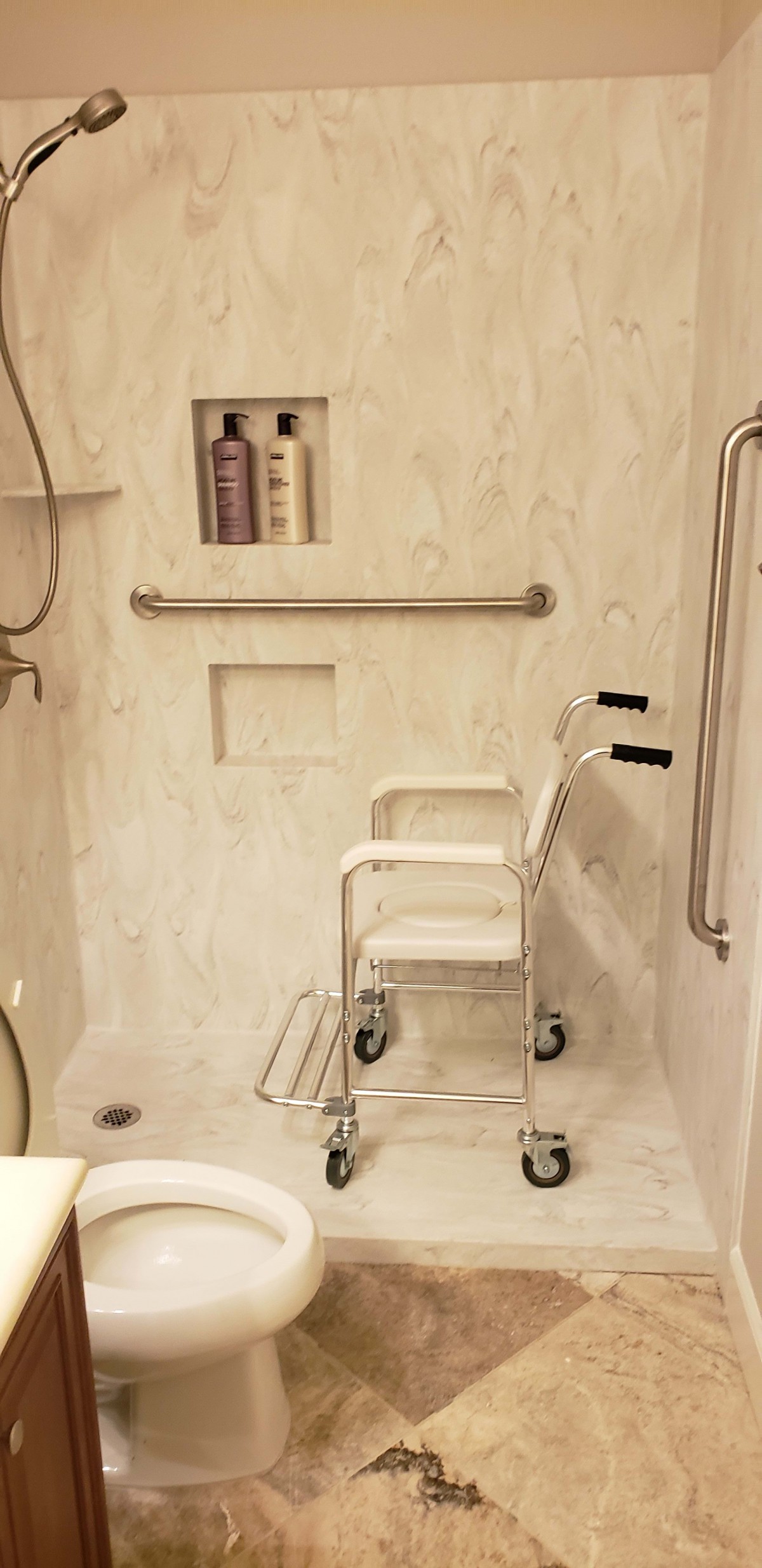 An accessible bathroom featuring a shower chair and grab bars for enhanced safety.